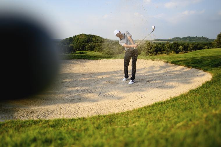 A golfer playing out of a bunker