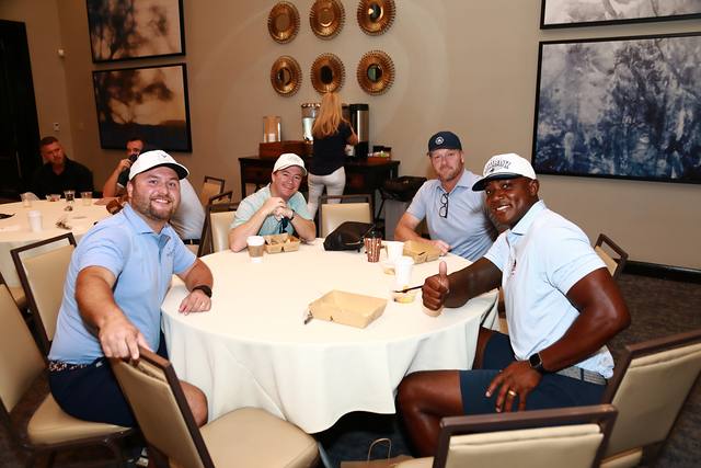 Four players smiling at a breakfast table