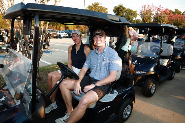 Two players in their cart in the lineup