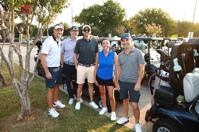 Five players posing by the line of carts
