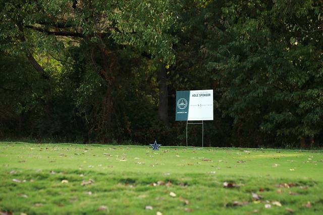 A hole sponsor sign on a shaded tee box