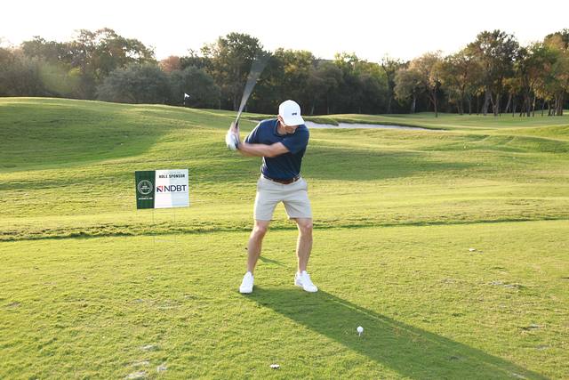 A player swinging beside the North Dallas Bank & Trust hole sponsor sign