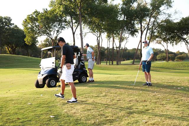 A group gathering near their cart on the fairway