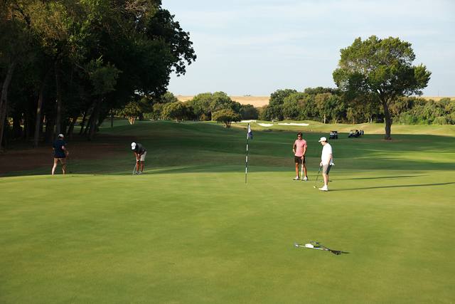 A group on a green seen from down the fairway