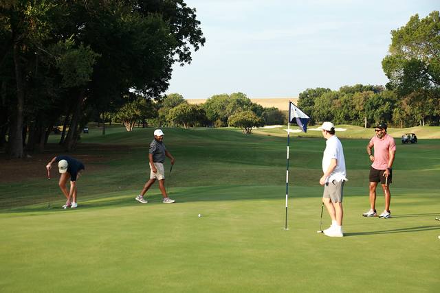 A group finishing a hole near the flag