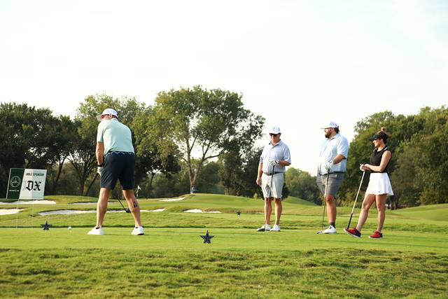 A player lining up his tee shot beside The Dallas Express hole sponsor sign