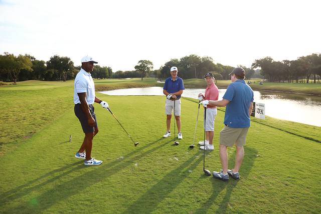 A group on a tee box beside the water