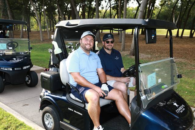 Two players smiling from their cart