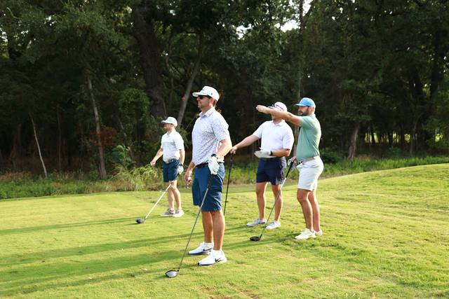 A group on the tee pointing down the fairway