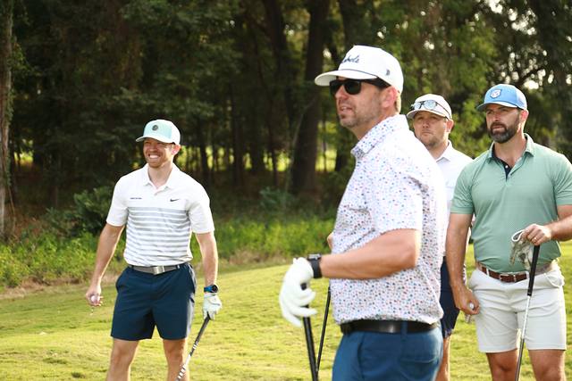 A group watching from the edge of the tee