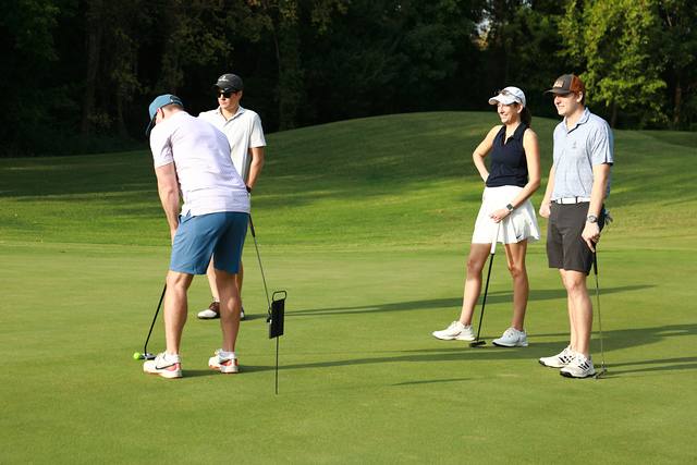 A player putting while his group watches