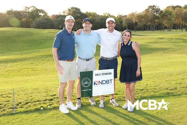 A group posing with the North Dallas Bank & Trust hole sponsor sign