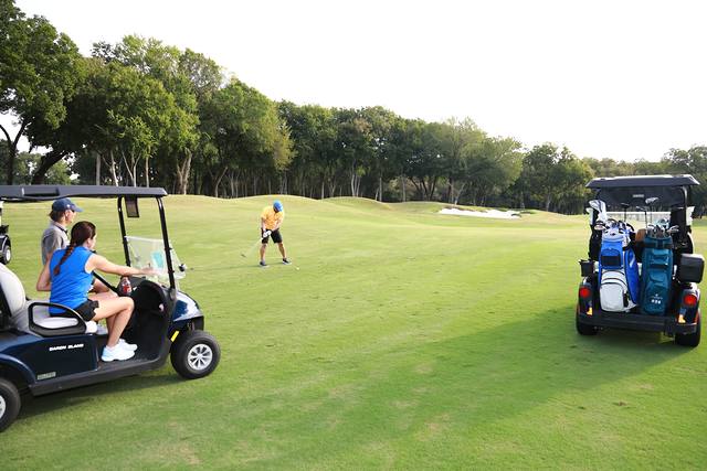Players and carts spread along a fairway