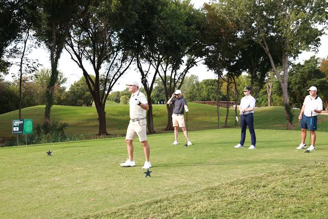 A group on a tee box under the trees