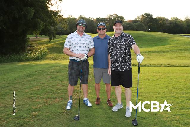 Three players posing on the course