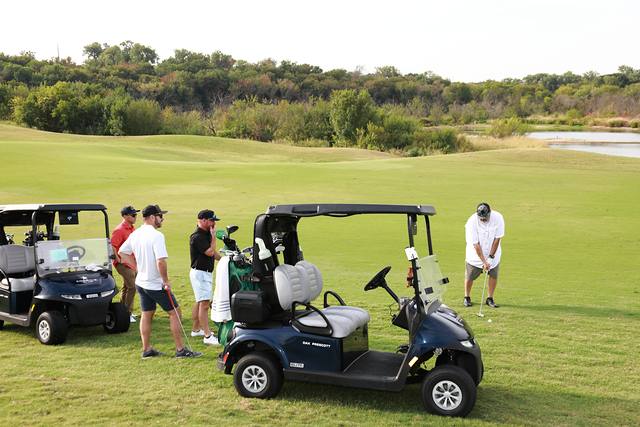 A group beside their carts on the fairway
