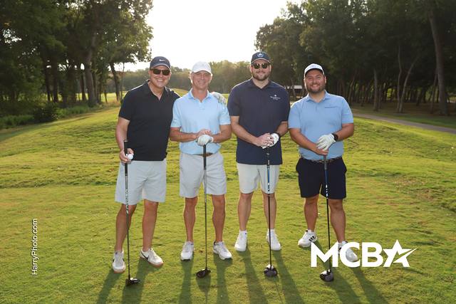 A group posing on the course in the morning sun