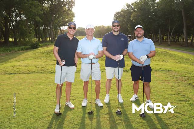 A group smiling on the course in the morning sun