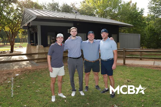 A group posing in front of an on course shelter