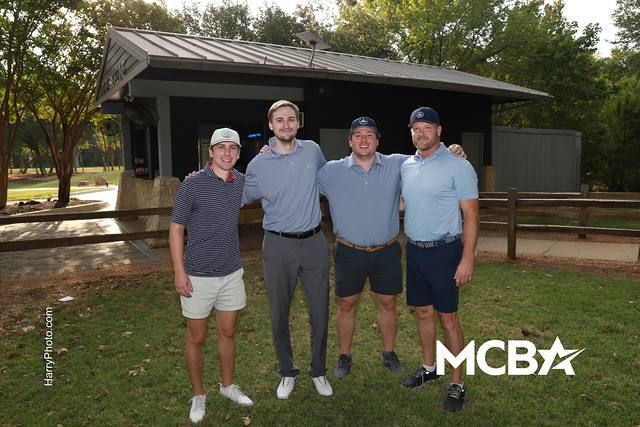 A group smiling in front of an on course shelter