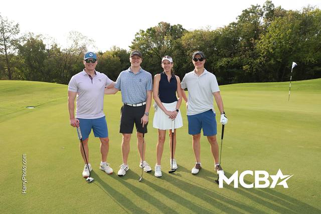 A group smiling on a green