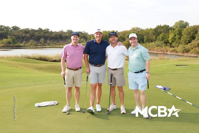 A group posing with water behind them