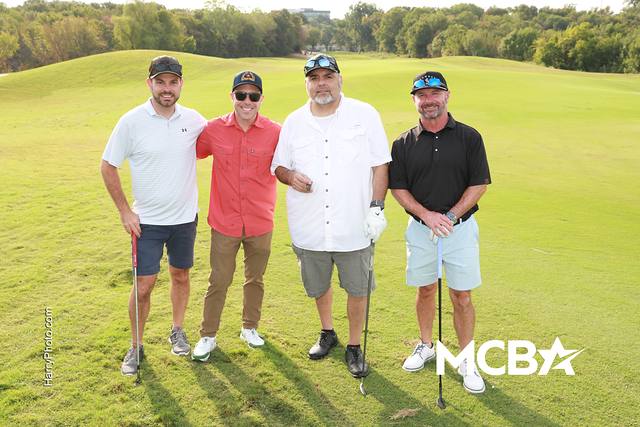 A group posing with their clubs on the course