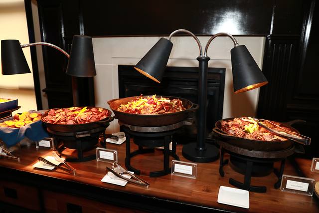 Barbecue in warming dishes on the buffet