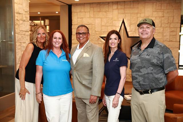 Five guests posing in front of the Cowboys star