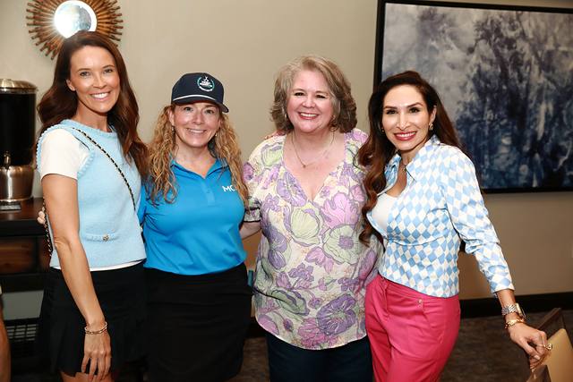 Four guests posing together in the clubhouse