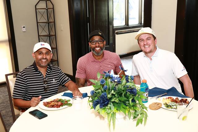Three players smiling at a lunch table