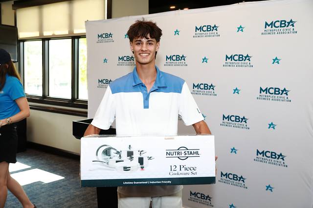 A winner holding a Nutri Stahl cookware set