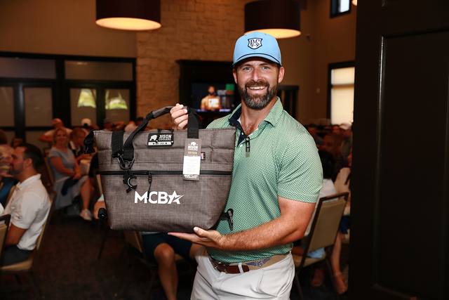 A winner holding an MCBA cooler bag