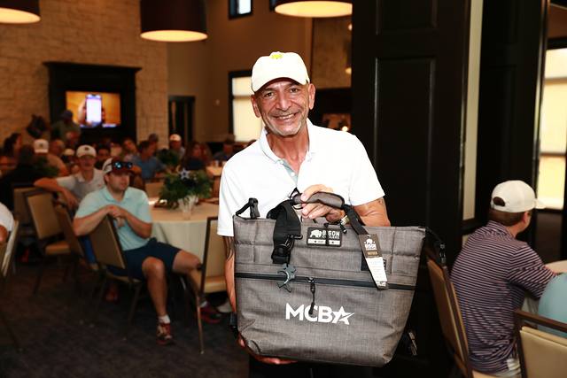 A winner smiling with his MCBA cooler bag
