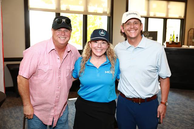 Two guests posing with an MCBA team member
