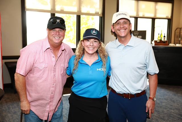 Two guests smiling with an MCBA team member